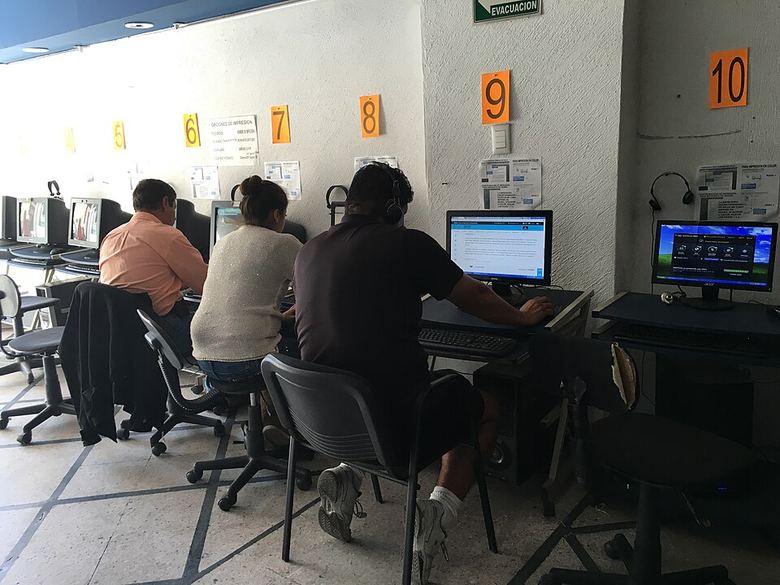 People using terminals at a public internet cafe